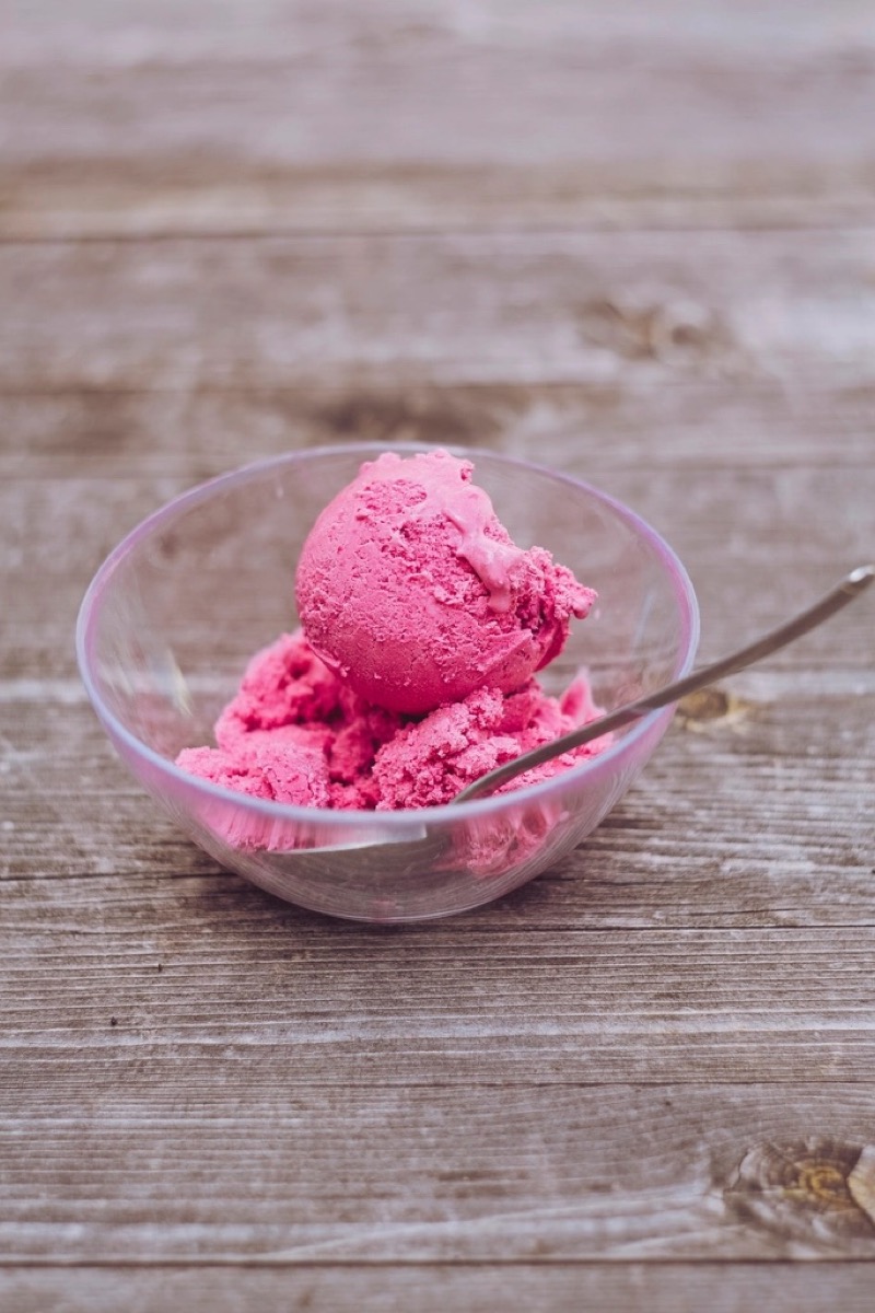 Roze schepijs in een glazen schaaltje op een houten tafel